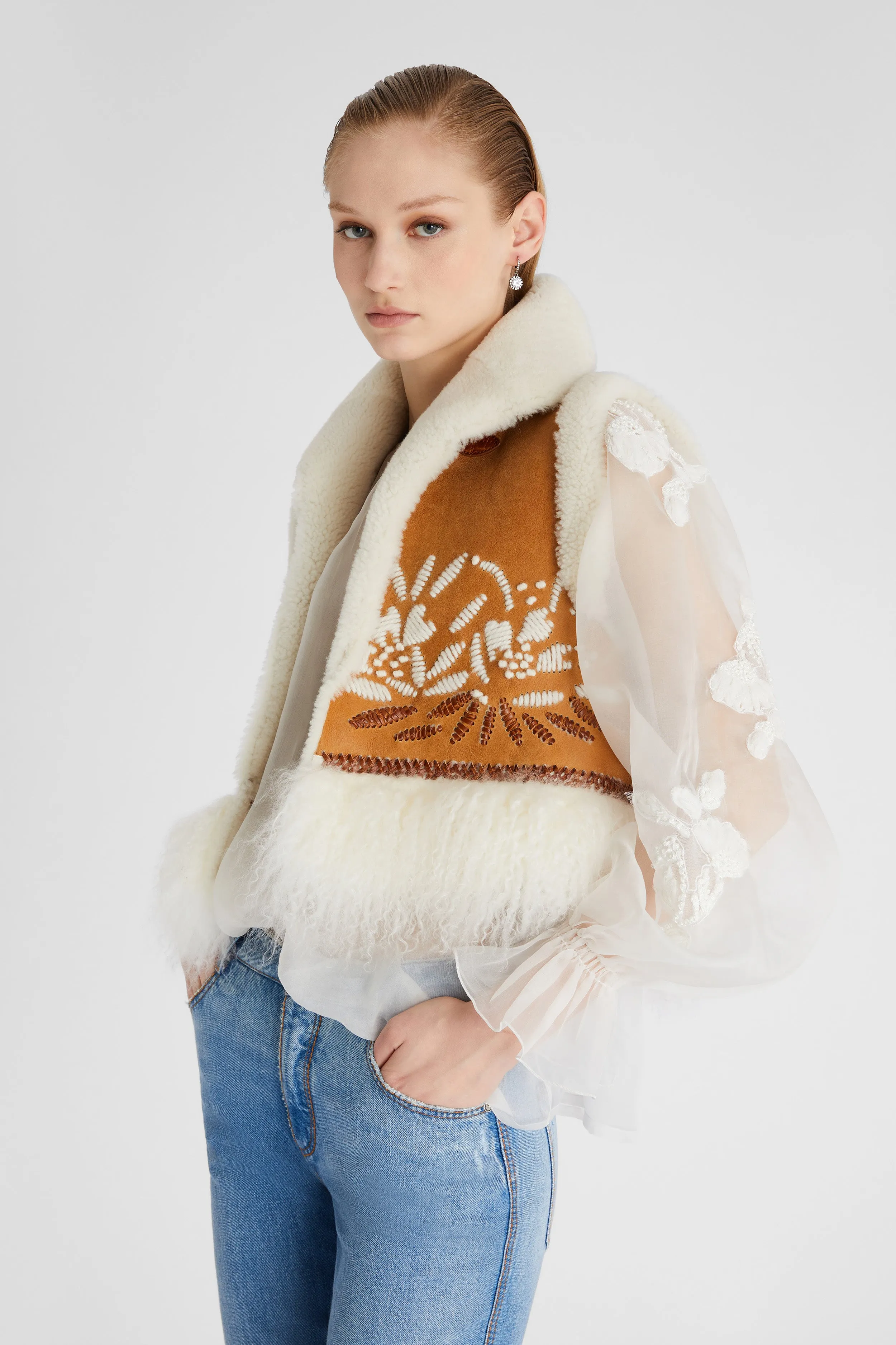 Shearling short waistcoat with handmade embroidery and fur on the bottom