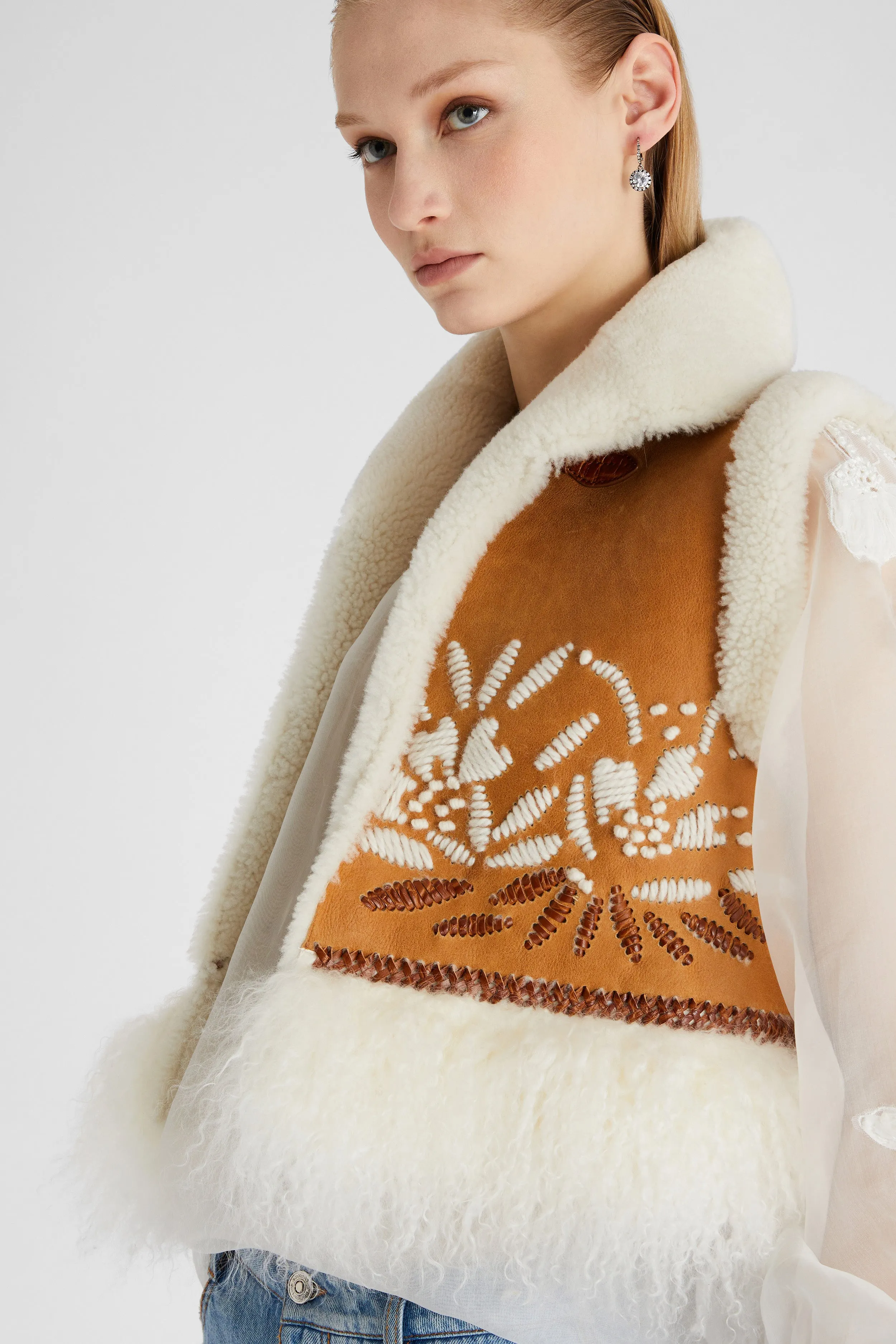 Shearling short waistcoat with handmade embroidery and fur on the bottom